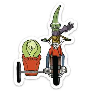 A sticker with an illustration of a green bean wearing goggles, a purple scarf and yellow sweater riding a red motorcycle with a sidecar carrying a Brussel sprout.