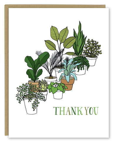A greeting card showing a hand-drawn illustration of a collection of houseplants. The card has a hand-lettered message reading, "Thank You." Shown with a Kraft paper envelope on a white background. 