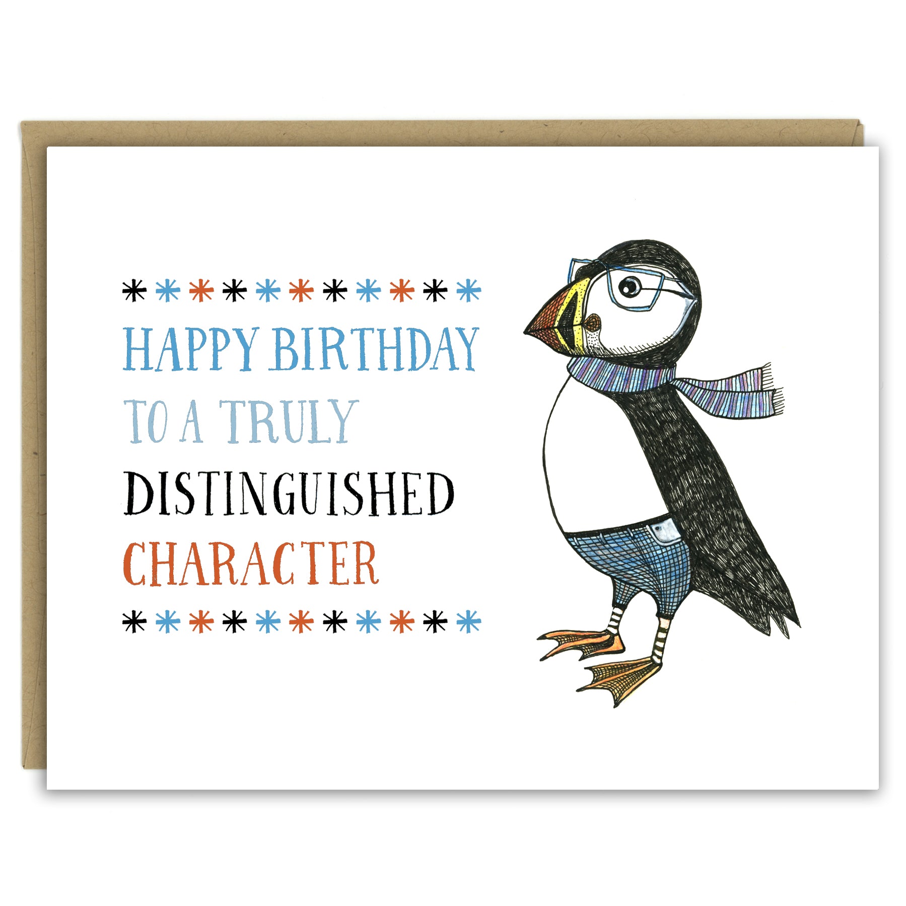 A greeting card with a hand-drawn ink illustration of a dapper puffin wearing glasses, jeans and a scarf. A hand-lettered message reads, "Happy Birthday to a truly distinguished character." Shown with a Kraft paper envelope on a white background. 